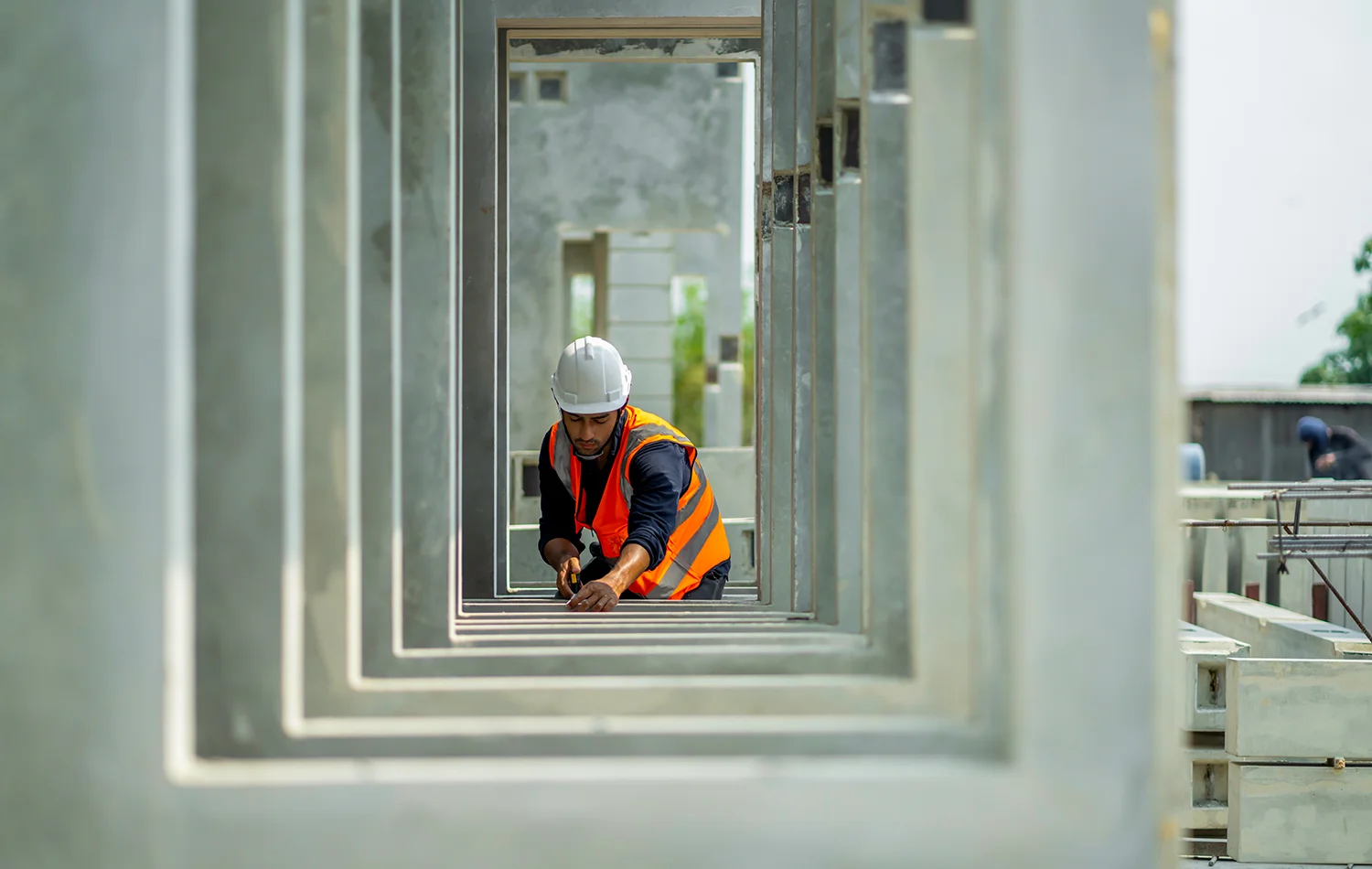 Accompagnement de collaborateurs vers et dans l'emploi - un ouvrier du bâtiment vêtu d'équipements de sécurité travaille sur des encadrements de fenêtres